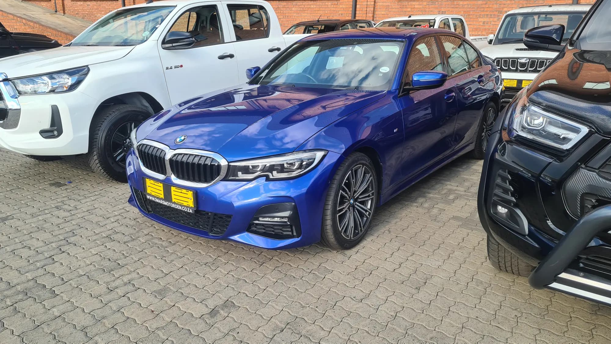 A blue BMW 3 Series photographed from the front quarter after detailing