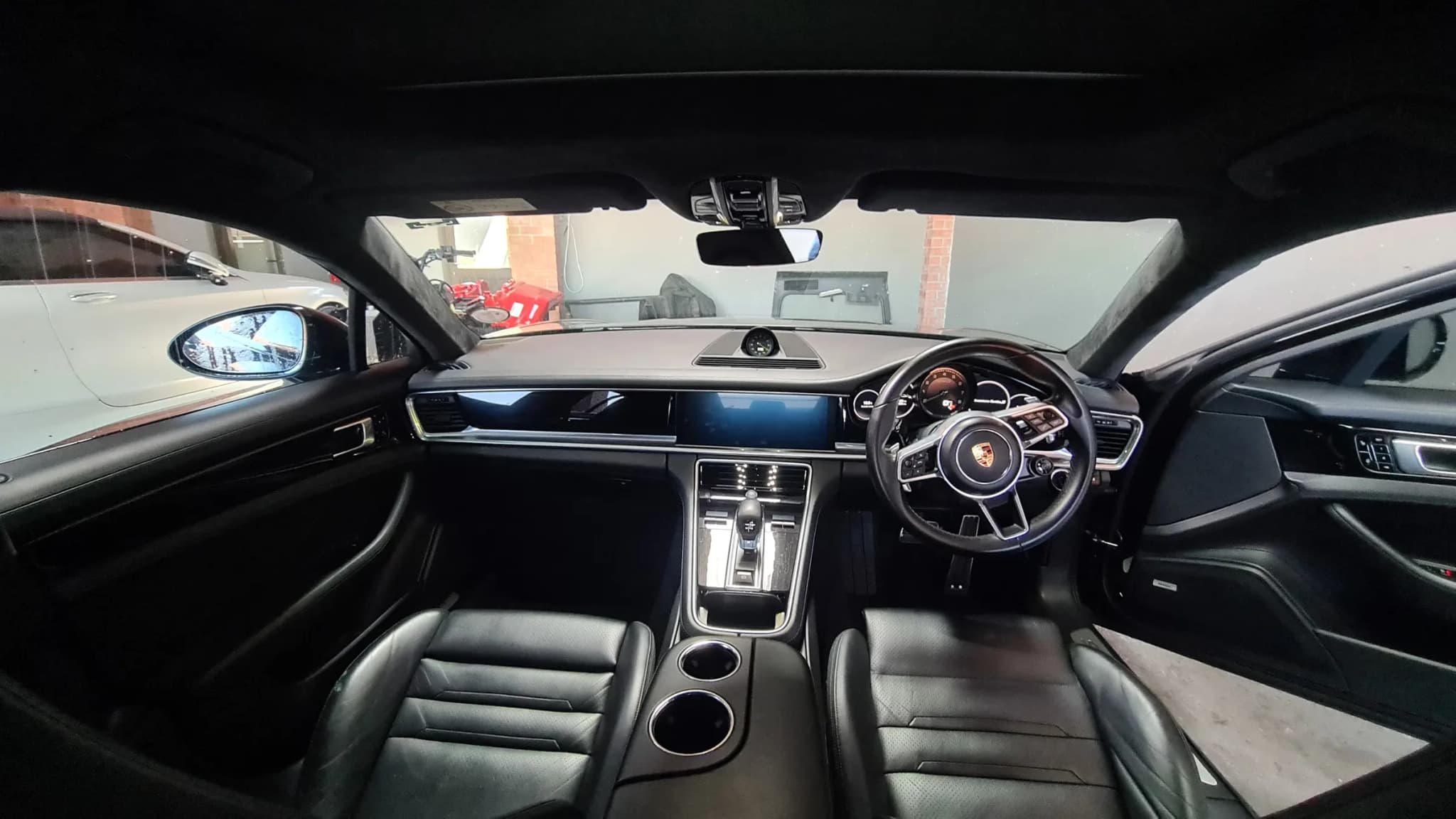 The full cabin of a Porsche Panamera photographed from the rear after a complete interior detail