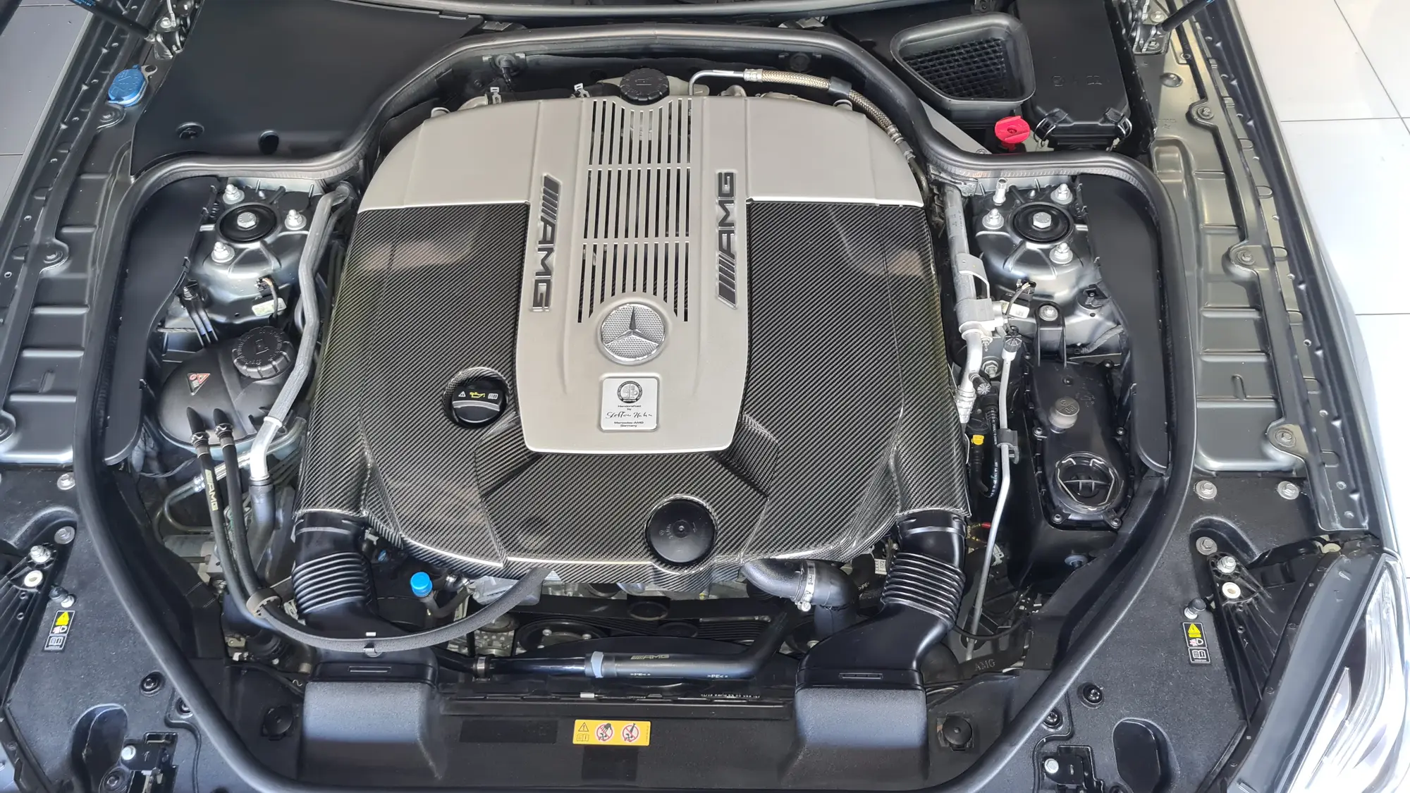 The same Mercedes-AMG V12 engine bay after a dry-biased clean and satin dressing